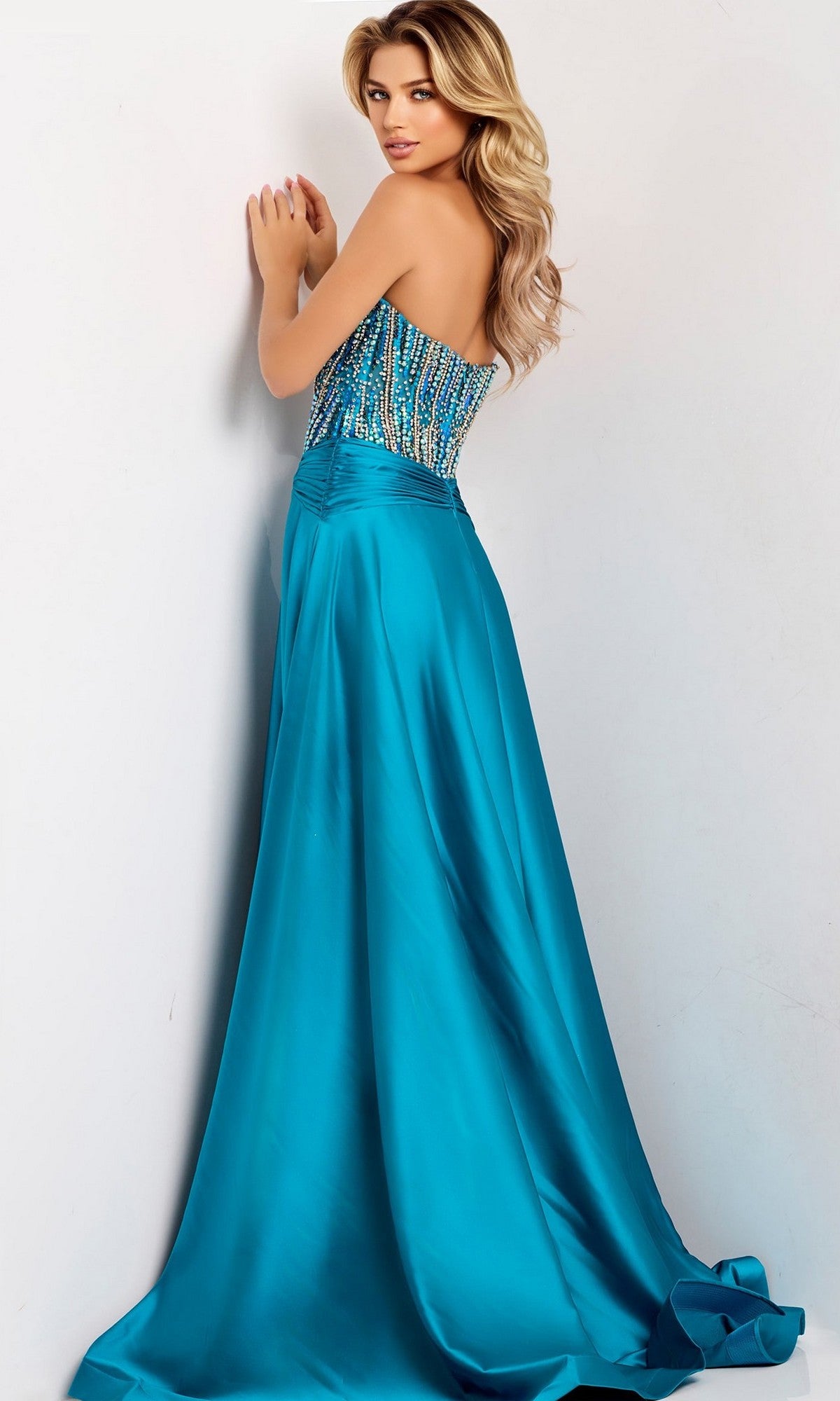 A woman models the Jovani 43729 long prom dress, showcasing its strapless beaded corset bodice and a flowing, floor-length A-line satin skirt against a light background.